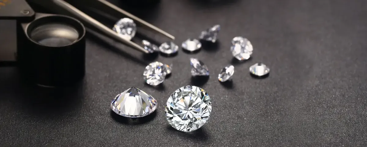 Loose diamonds with jeweler loupe and tweezers