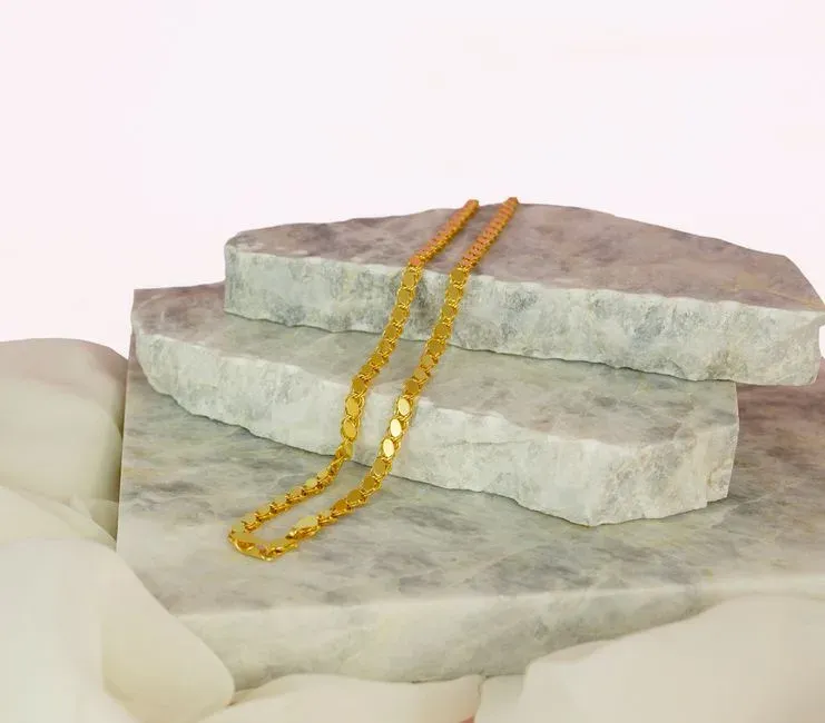 Gold chain arranged on pale stone blocks