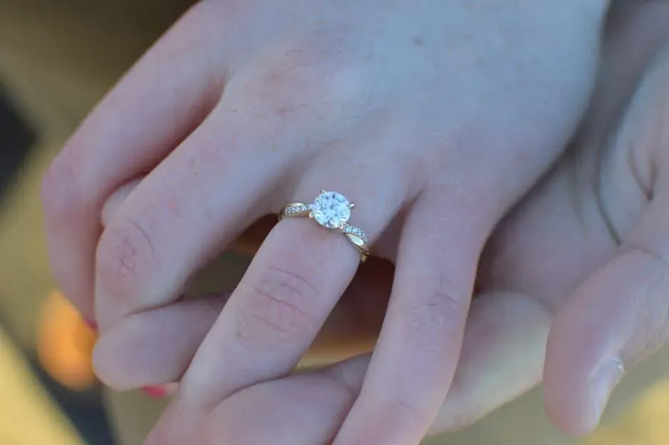 White-metal solitaire ring worn on a hand
