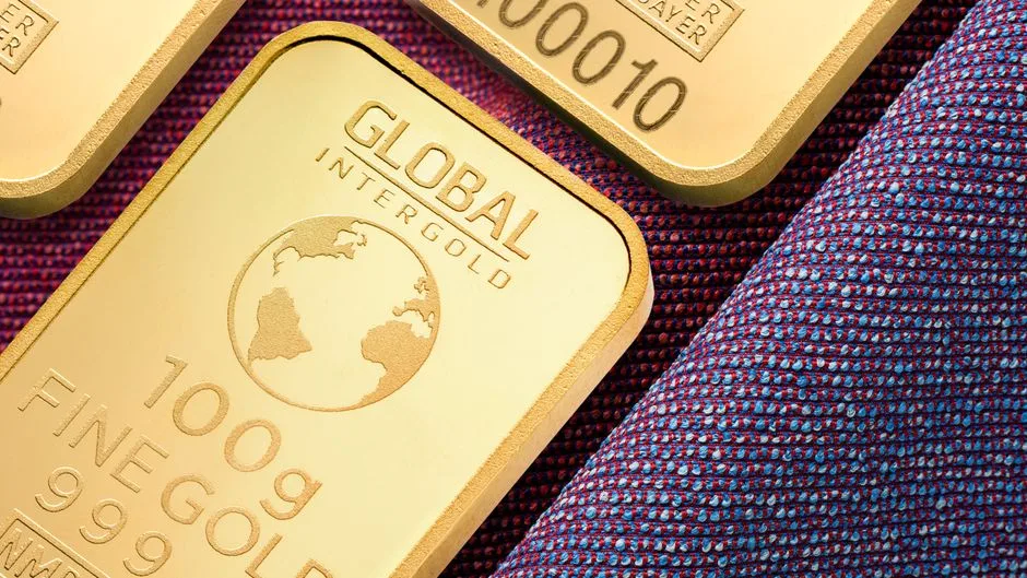 Close view of gold-colored bars with stamped weight and fine-gold markings