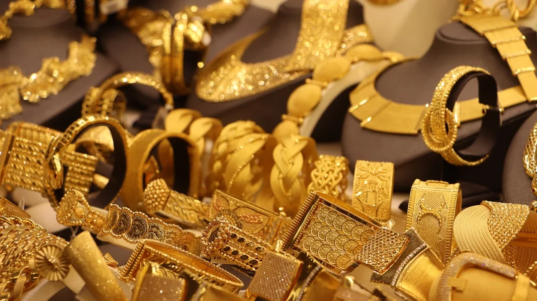 Gold-colored necklaces and substantial bangles arranged on jewelry display stands