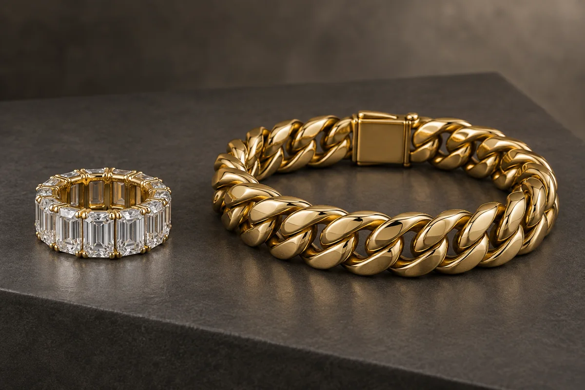 Large emerald-cut diamond eternity band beside a heavy yellow-gold Cuban-link bracelet
