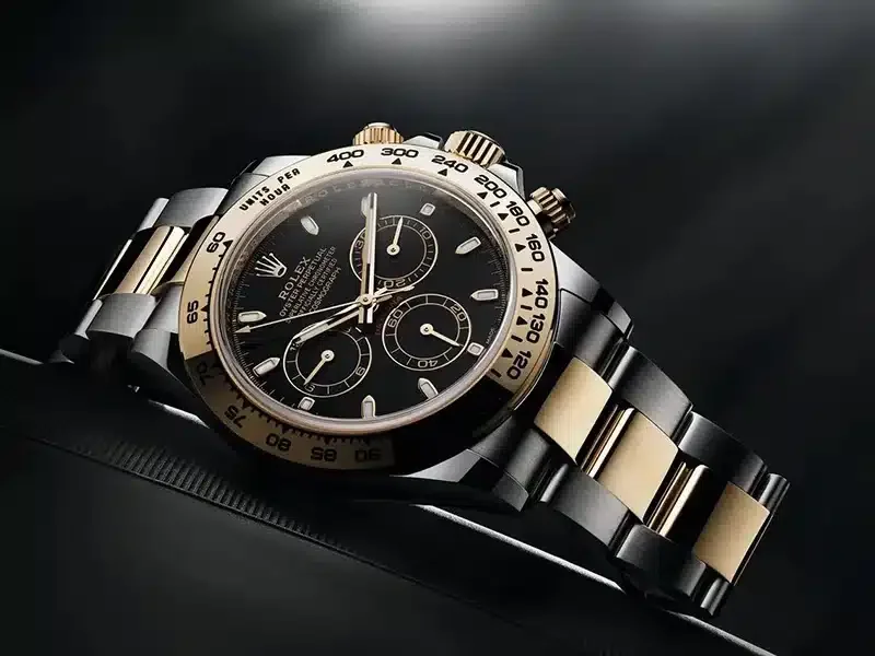 Rolex Cosmograph Daytona with a black dial and gold and steel bracelet