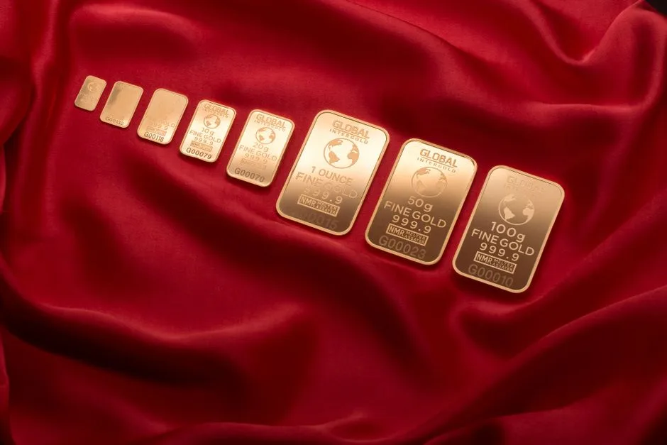 Gold-colored bars of different marked weights arranged on red fabric