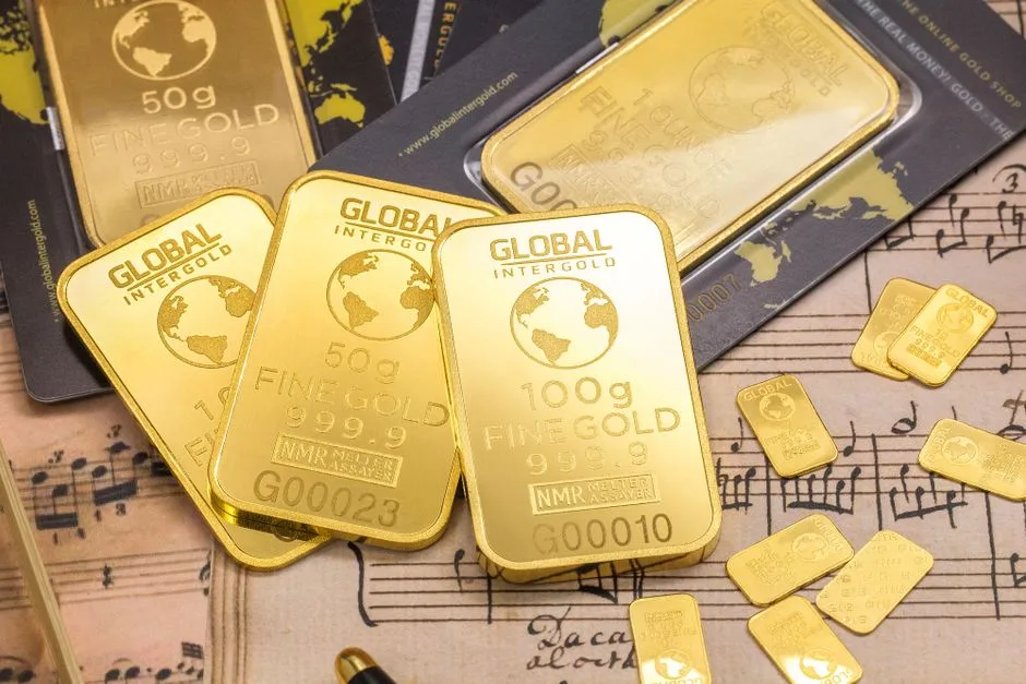 Gold-colored bars with weight and fineness markings on printed sheet music