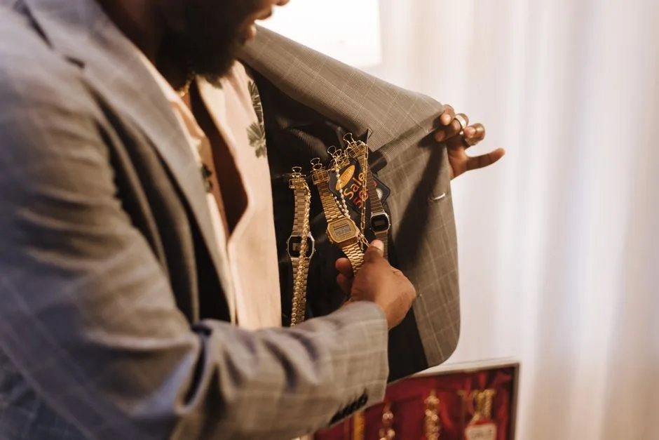 Person holding a jacket open to show several wristwatches