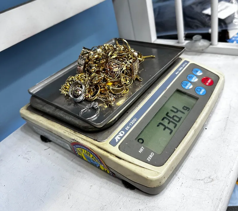 Assorted jewelry piled on the tray of a digital scale