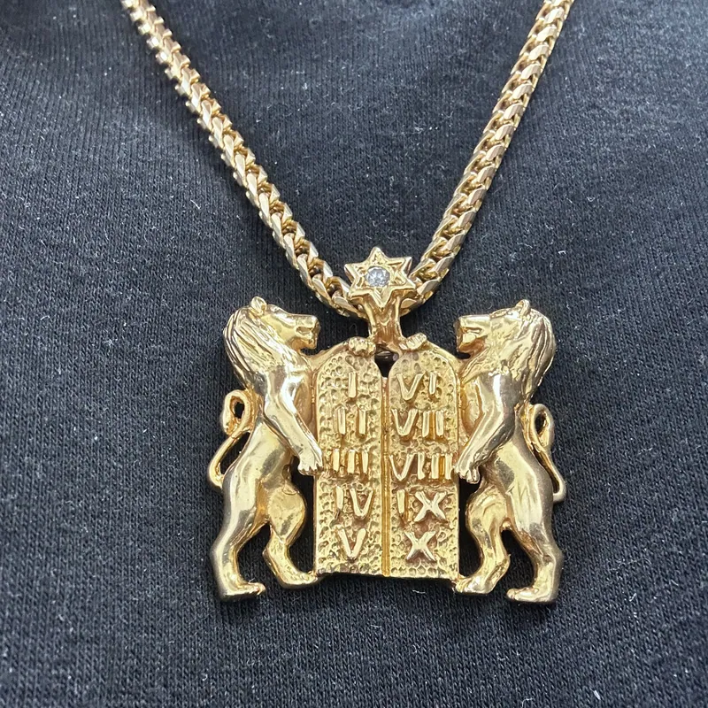 Yellow-metal chain with a pendant showing two lions beside tablets