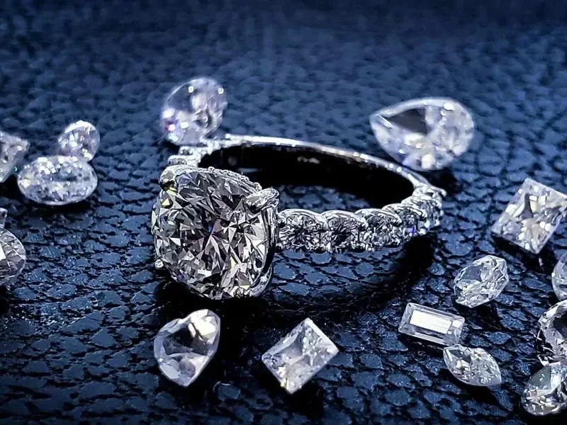 A polished diamond ring and loose stones shown for illustration