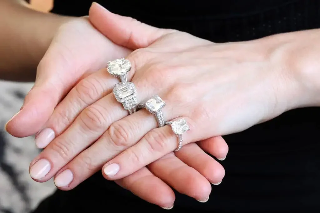 Several substantial diamond rings displayed on hands