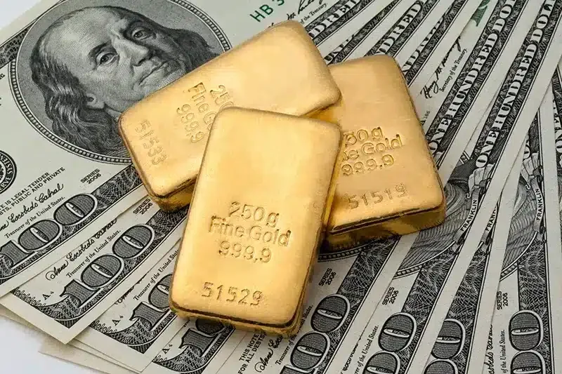 Gold bars displayed with United States banknotes