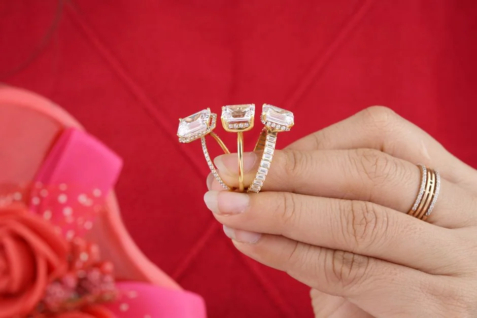 Three gold rings with substantial rectangular center stones worn together